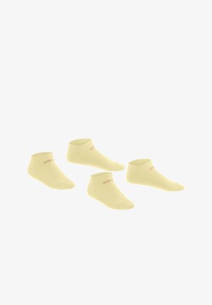 Vier Paar hellgelbe, niedrig geschnittene Knöchelsocken mit dezentem rotem Branding am Bündchen, auf weißem Hintergrund angeordnet.