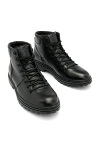 Czarne skórzane botki za kostkę o teksturowanej powierzchni, z okrągłym noskiem i sześcioma oczkami. Gumowa podeszwa z bieżnikiem dla lepszej przyczepności. Podszewka dla dodatkowego ciepła.