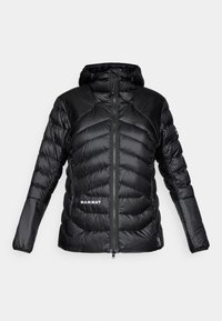 Černá prošívaná bunda s kapucí, vyrobená z lehkého materiálu, s prošívanými částmi, předním zipem a logem "MAMMUT" na lemu a rameni.