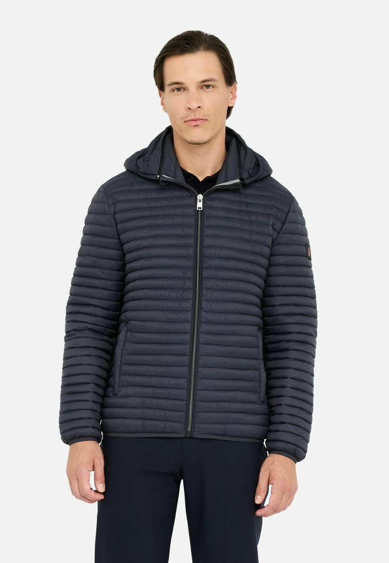 Veste rembourrée marine avec fermeture éclair à l'avant et capuche. Texture matelassée, poignets élastiqués et patch logo sur la manche.