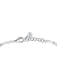 Bracciale in argento con chiusura a morsetto, anelli interconnessi e un charm decorativo con design floreale su un disco rotondo.