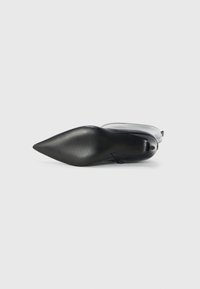 Zwarte puntige schoen met een glad leren bovenwerk en een gestructureerde rubberen zool. Heeft een slank ontwerp met minimale hardware en stiksels.