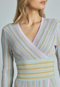 Mehrfarbiges geripptes Kleid mit vertikalen Streifen in Pastellfarben, darunter Rosa, Blau und Gelb, mit V-Ausschnitt und taillierter Passform.