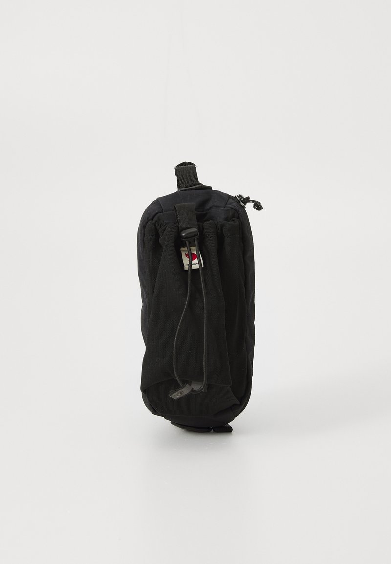 Sacca in tessuto nero con chiusura a zip, dotata di un anello per appenderla e coulisse. Forma cilindrica sottile con superficie testurizzata.