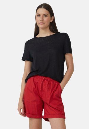 T-shirt noir à manches courtes avec un col rond, associé à un short rouge à taille élastique, avec des manches retroussées et des poches latérales.