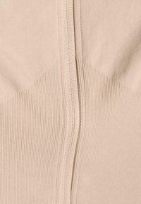 Beige zippered garment with ribbed texture and smooth panels; features a central zipper running vertically along the front.