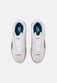 Baskets en cuir blanc avec un accent rose, du daim gris et des détails bleus. Elles présentent un système de laçage blanc et une semelle extérieure en caoutchouc naturel.