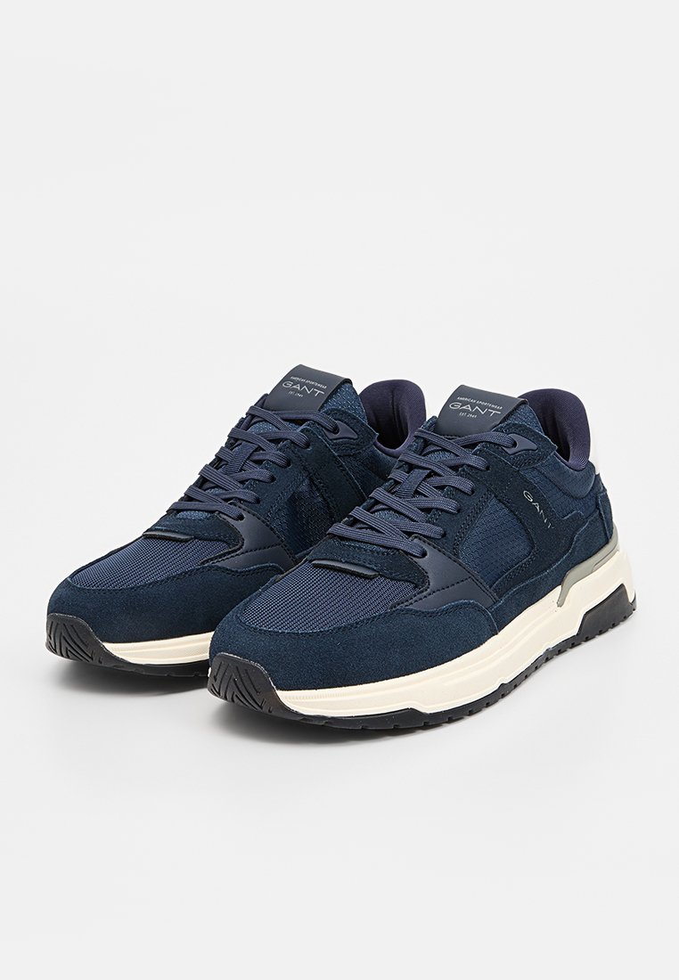 Sneaker blu navy realizzati con un mix di materiali in camoscio e rete. Presentano una spessa suola bianca e una suola in gomma nera texturizzata. Logo sulla linguetta.