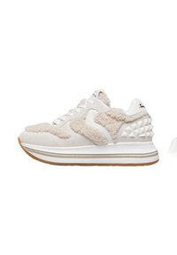 Sneakers beige in suede con texture pelosa, dettagli bianchi e borchie a forma di piramide. Presentano una spessa suola bianca con una base in gomma.