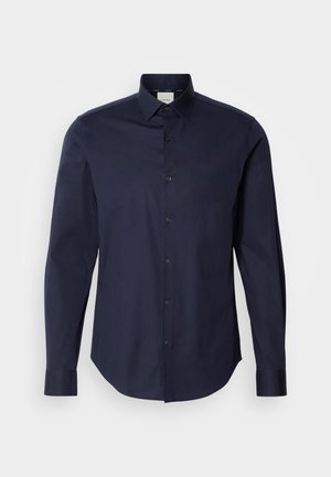 Camisa azul marino de botones, hecha de algodón. Presenta mangas largas, un cuello en punta y una tapeta con botones a juego. Textura suave.