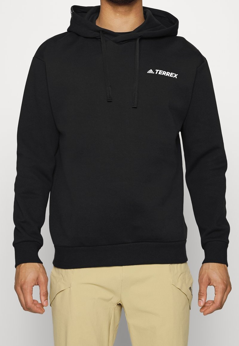 Sudadera con capucha negra hecha de una mezcla de algodón. Cuenta con un bolsillo canguro en la parte frontal y un pequeño logo blanco "Terrex" en el pecho.