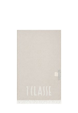 Tappeto rettangolare beige con bordi frangiati e la parola "1 CLASSE" tessuta in una sottile tonalità più chiara vicino a un'estremità.