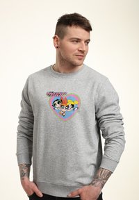 Grå sweatshirt i bomull, med en färgglad hjärtgrafik som har tre stiliserade tecknade figurer vid bröstområdet.