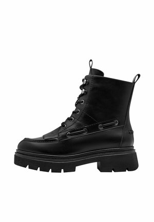 Schwarzer Leder-Schnür-Kampfstiefel mit dicker Profilsohle, Zuglaschen an Ferse und Zunge sowie dekorativer Seitennaht auf weißem Hintergrund.