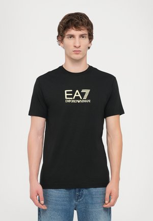 Zwarte katoenen T-shirt met een gouden EA7 Emporio Armani-logo op de borst. Korte mouwen en een klassieke ronde halslijn.