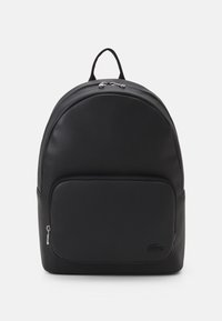 Black leather backpack with rounded shape, top handle, front zip pocket, and subtle logo; features smooth texture and silver hardware accents.