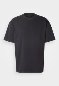 Camiseta de algodón de manga corta negra, con un cuello redondo y un sutil logo en el cuello. Textura suave y corte holgado.