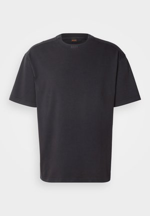 T-shirt noir à manches courtes en coton, avec un col rond et un logo discret au niveau du col. Texture lisse avec une coupe décontractée.