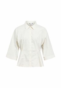 Chemise blanche à boutons avec manches larges aux trois quarts, col pointu et taille légèrement évasée, présentée sur un fond blanc.