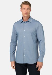 Camicia a maniche lunghe azzurro chiaro con colletto classico, texture sottile e bottoni sul davanti; vestibilità slim con orlo arrotondato.