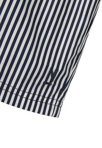 Navy- ja valkoviiruinen kangas, jossa on sileä pinta. Hieman brodeerattu 'N'-kirjailu helmassa. Viimeistelty istuva leikkaus.