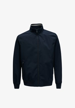 Laivastonsininen kevyt takki, jossa on korkea kaulus, etuvetoketjukiinnitys, vetoketjulliset sivutaskut sekä resorit hihansuissa ja helmassa.