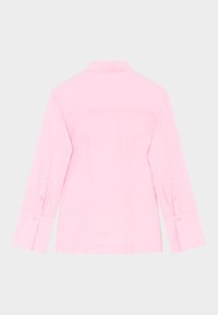 Rožinės spalvos ilgomis rankovėmis marškiniai su apykakle, turintys tiesų kirpimą, užsegamus rankogalius ir lygų, vienodą audinio tekstūrą. Rodoma galinė vaizdo pusė.