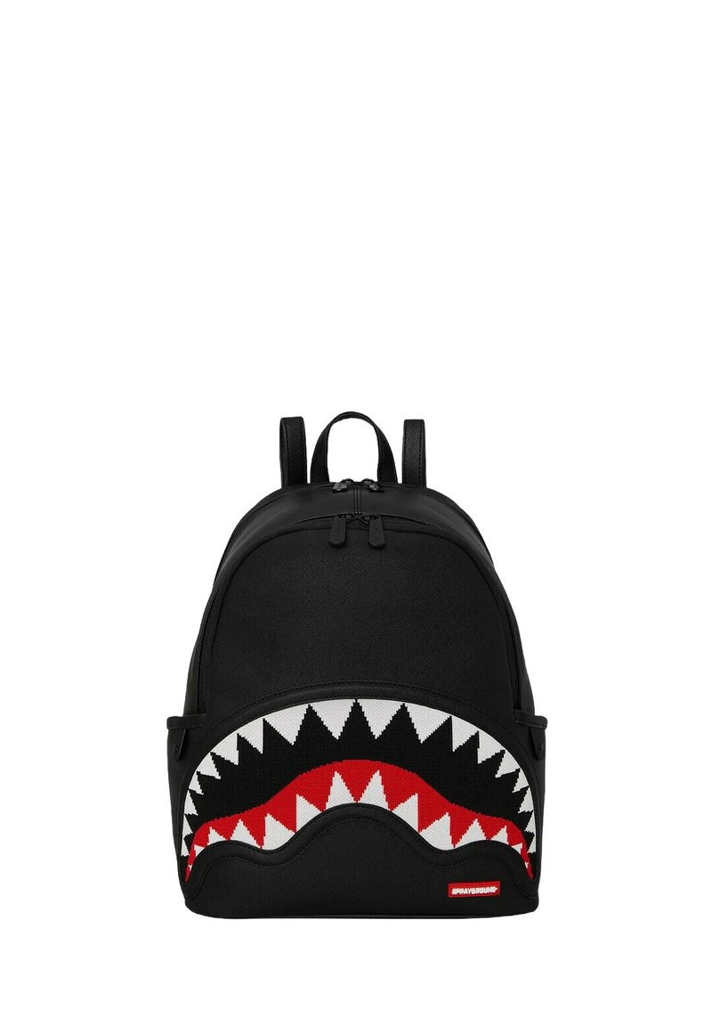 Zaino nero con design a bocca di squalo, caratterizzato da denti bianchi e dettagli rossi. Realizzato in tessuto, con due spallacci regolabili e chiusura con zip.