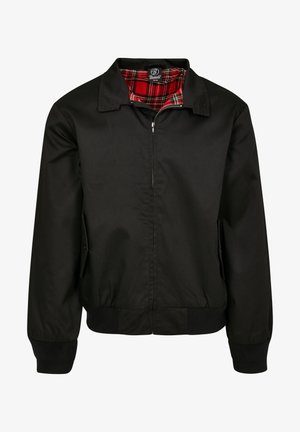 Giubbotto bomber nero con zip sul davanti, polsini e orlo a coste, con un rivestimento a quadri rosso e nero visibile al colletto.