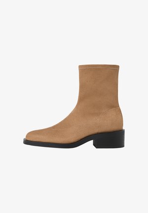 Hellbraune Wildleder-Ankle Boots mit quadratischer Spitze, niedrigem Blockabsatz und nahtlosem Design. Mit dezenten Nähten entlang der Kanten.
