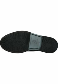 Suela de goma negra con un patrón de superficie texturizado y un tacón ligeramente elevado. Presenta una plantilla suave y gris con detalles del logo en relieve.