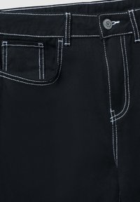 Pantaloni in denim nero con cuciture bianche a contrasto, cinque tasche, chiusura con bottone e passanti per cintura. Tessuto durevole e texturizzato.