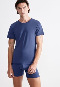 Navy blue, short-sleeve t-shirt and matching boxer shorts made of smooth, stretch fabric, featuring a simple design with no visible patterns.