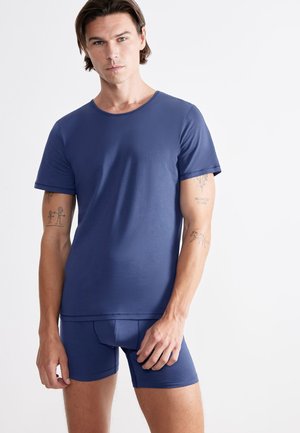 T-shirt bleu marine à manches courtes et boxer assorti en tissu lisse et extensible, avec un design simple sans motifs visibles.