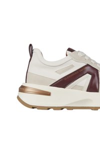 Sneaker bianca e bordeaux con suola chunky, dettagli in pelle testurizzata e un sottile particolare in bronzo sul tallone.