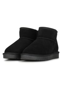 Botines de ante negro con punta redondeada, textura suave, diseño sencillo y suela de goma con un ligero patrón de tracción.