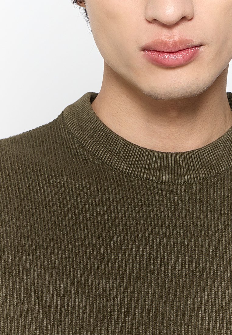 Maglione a coste di un verde oliva con colletto rotondo e tessuto testurizzato, che mette in evidenza sottili righe verticali e un design aderente.