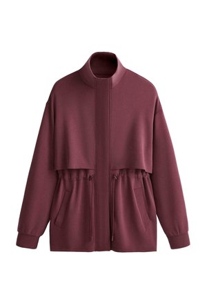 Bordová bunda na zips s vysokým golierom, elastickým sťahovaním v páse, dlhými rukávmi s manžetami, prednými vreckami a vrstveným detailom na hrudi.