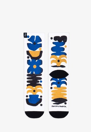 Calcetines de algodón hasta la rodilla con un fondo blanco y patrones abstractos en azul, amarillo y negro. Acentos en la punta en negro, logo en la parte inferior.