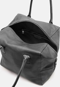 Graue Leder-Shopper-Tasche mit einem Reißverschluss, zwei stabilen Griffen und einfachen Steppdetails. Das Innere ist ungefüttert und geräumig.