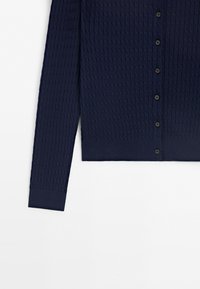 Navy blue long-sleeve knitted cardigan with a textured pattern and black buttons down the front.