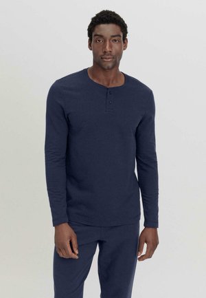 Marineblaues Langarm-Henley-Shirt aus weichem Baumwollstoff, mit rundem Halsausschnitt, Knopfleiste mit drei Knöpfen und taillierten Ärmeln.
