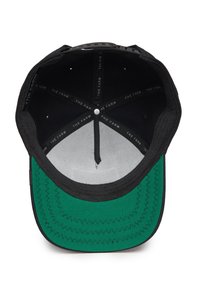 Gorra negra con visera verde, con un interior que presenta un forro gris suave y un patrón de costura circular. Tejido texturizado con orificios de ventilación.