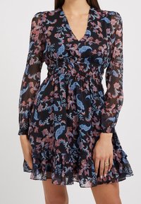 Schwarzes Blumenkleid mit langen Ärmeln, V-Ausschnitt, gerafftem Bund und schwingendem Saum. Enthält farbenfrohe Paisleymuster und Blumenmuster.