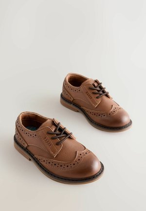 Barna bőrcipő, texturált dizájnnal, perforált részletekkel, kerek orral, fűzős záródással és kontrasztos talppal.