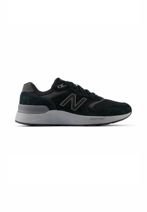 Zapatilla New Balance negra y gris con parte superior de malla y ante, cierre de cordones delantero y suela gruesa acolchada con la etiqueta Fresh Foam.