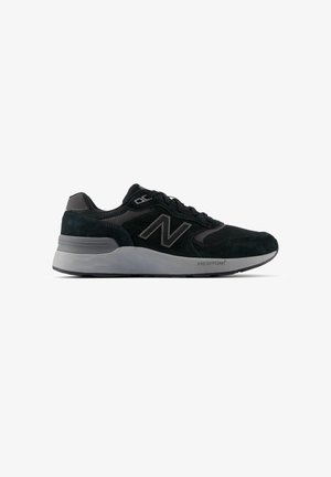 Musta ja harmaa New Balance -lenkkari, jossa verkko- ja mokkanahkainen päällinen, nauhoitukset edessä ja paksu pehmustettu Fresh Foam -pohja.