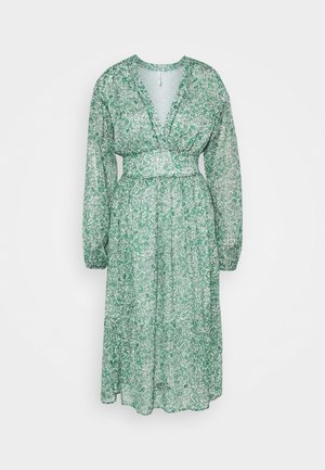 Robe midi à manches longues et col en V, à fleurs vertes et blanches, avec une taille cintrée et une jupe légèrement évasée, sur un fond uni.