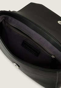 Schwarze Lederhandtasche mit strukturiertem Äußeren, ausgestattet mit einem gefütterten Innenraum, einer Reißverschlusstasche und einem Druckknopfverschluss. Mit silberfarbenen Beschlägen akzentuiert.