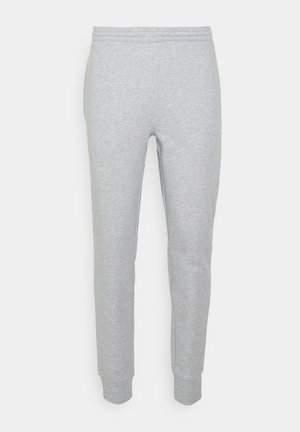 Pantalones de chándal de algodón grises con pierna ajustada, cinturilla elástica y puños acanalados. Diseño minimalista sin patrones ni acentos distintivos.